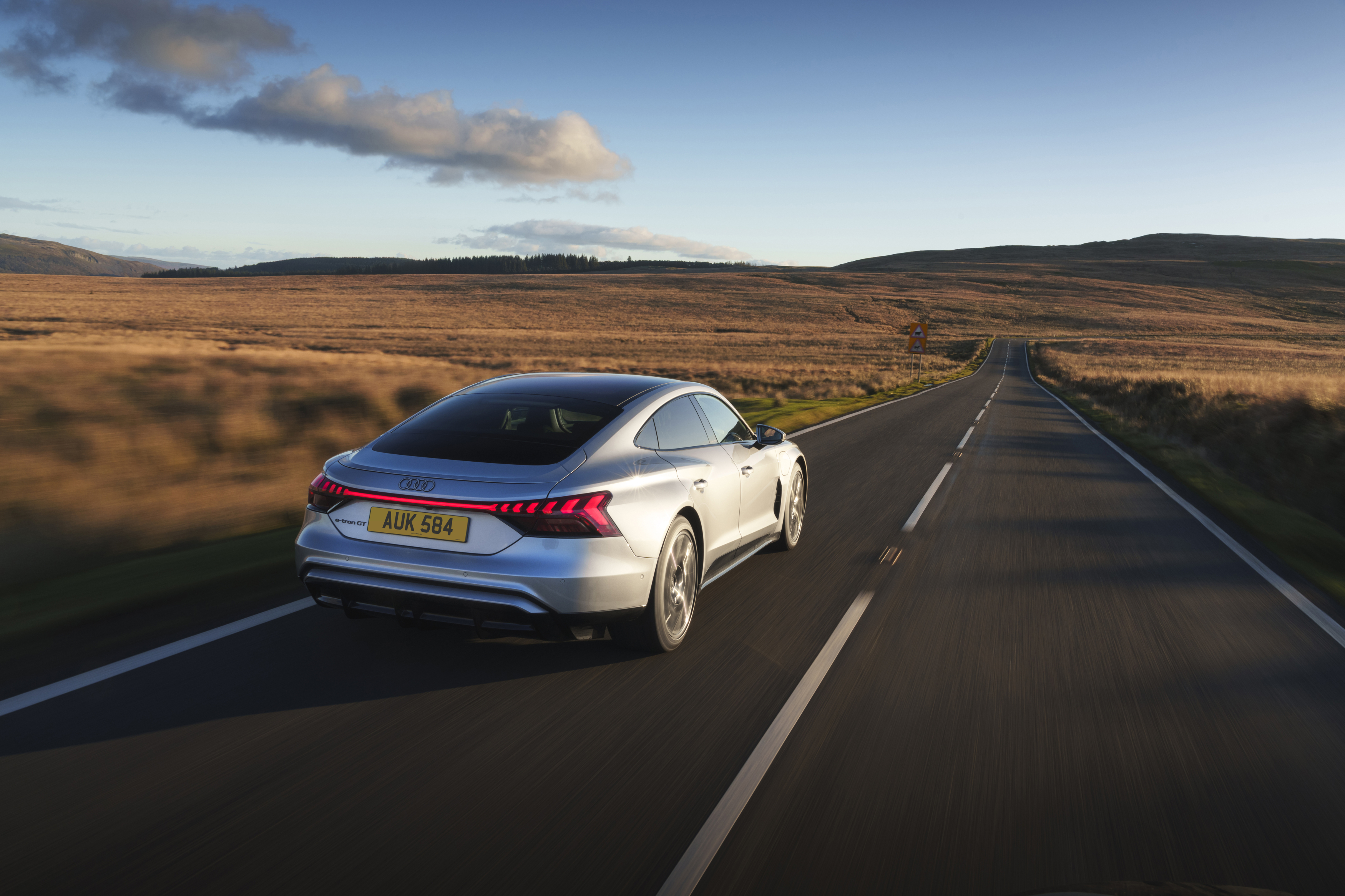 Silver Audi driving along a quiet rural road through open moorland