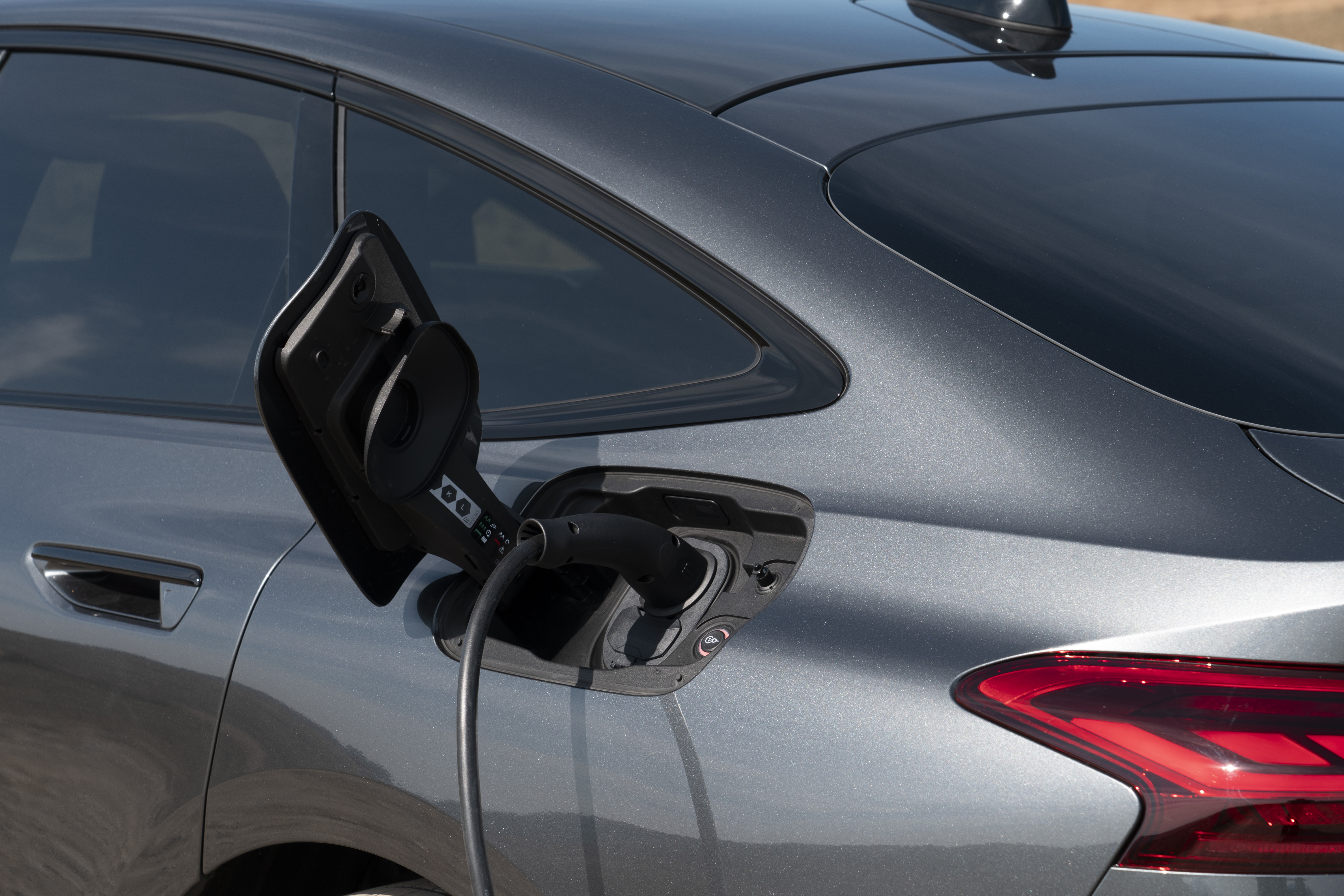 Close-up of an Audi Q6 e-tron connected to an electric charging cable