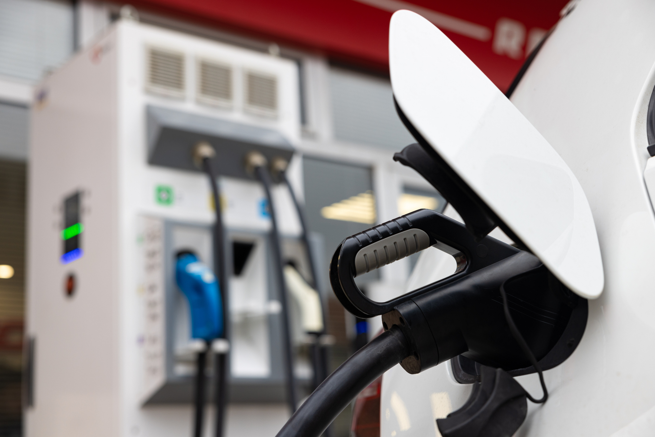 Close up of charger plug into electric car at the electric vehicle charging station.  