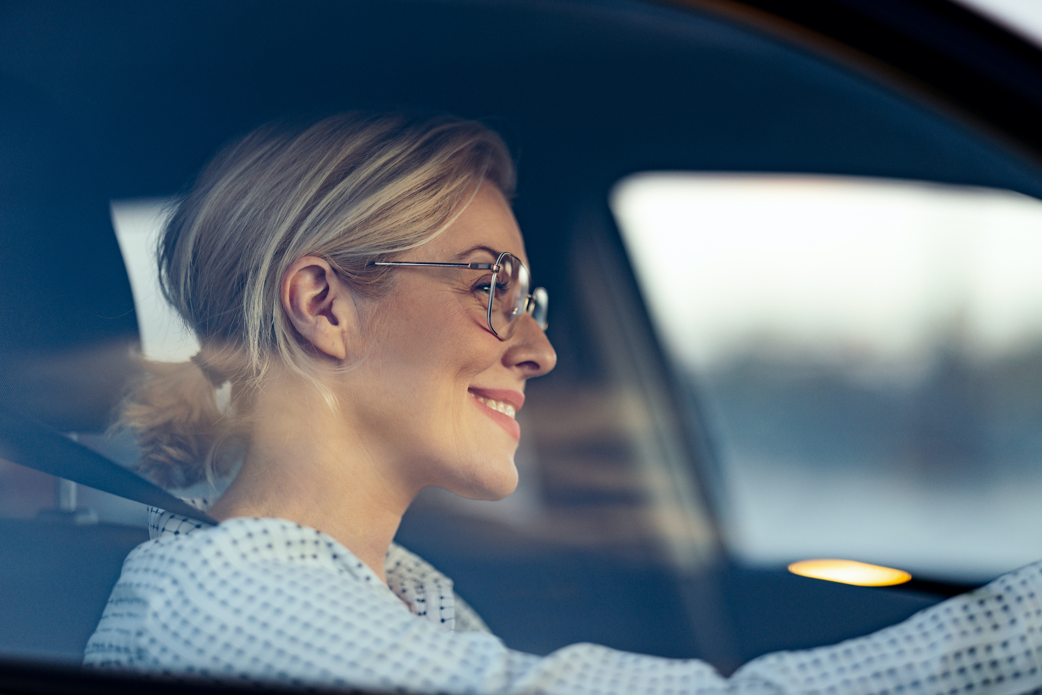 Happy business woman traveling with her car around the city.