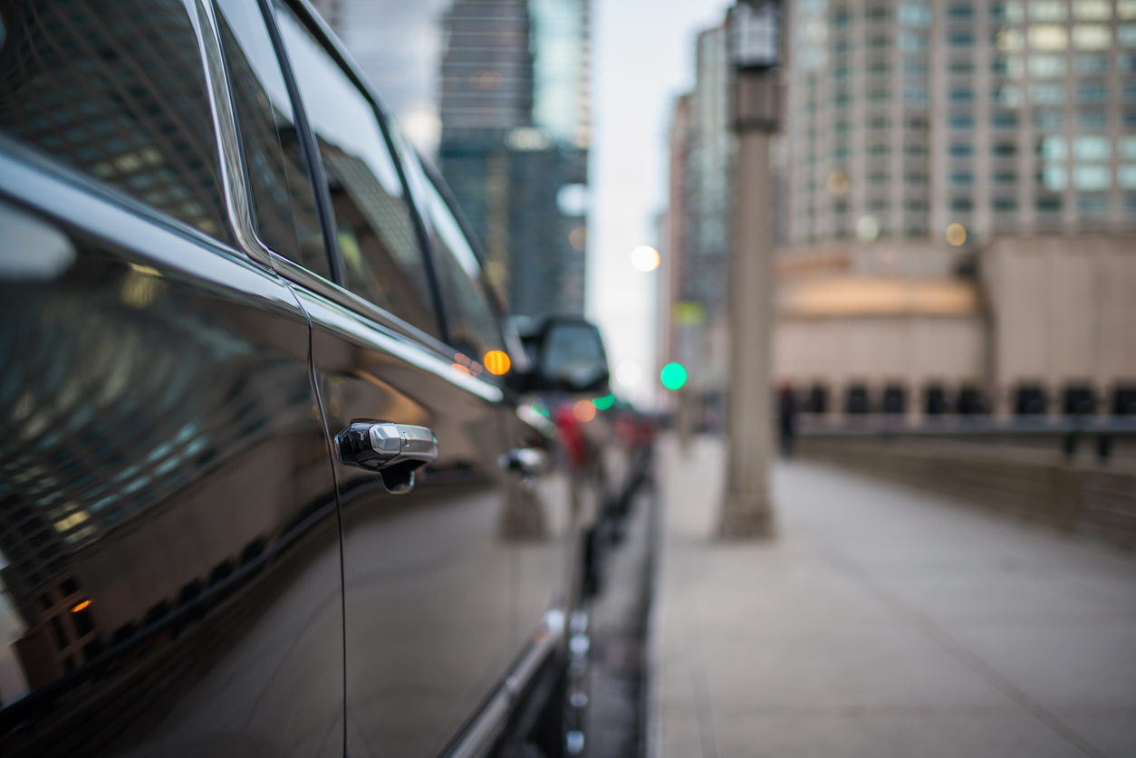 Passenger door handle of a black SUV in the city.